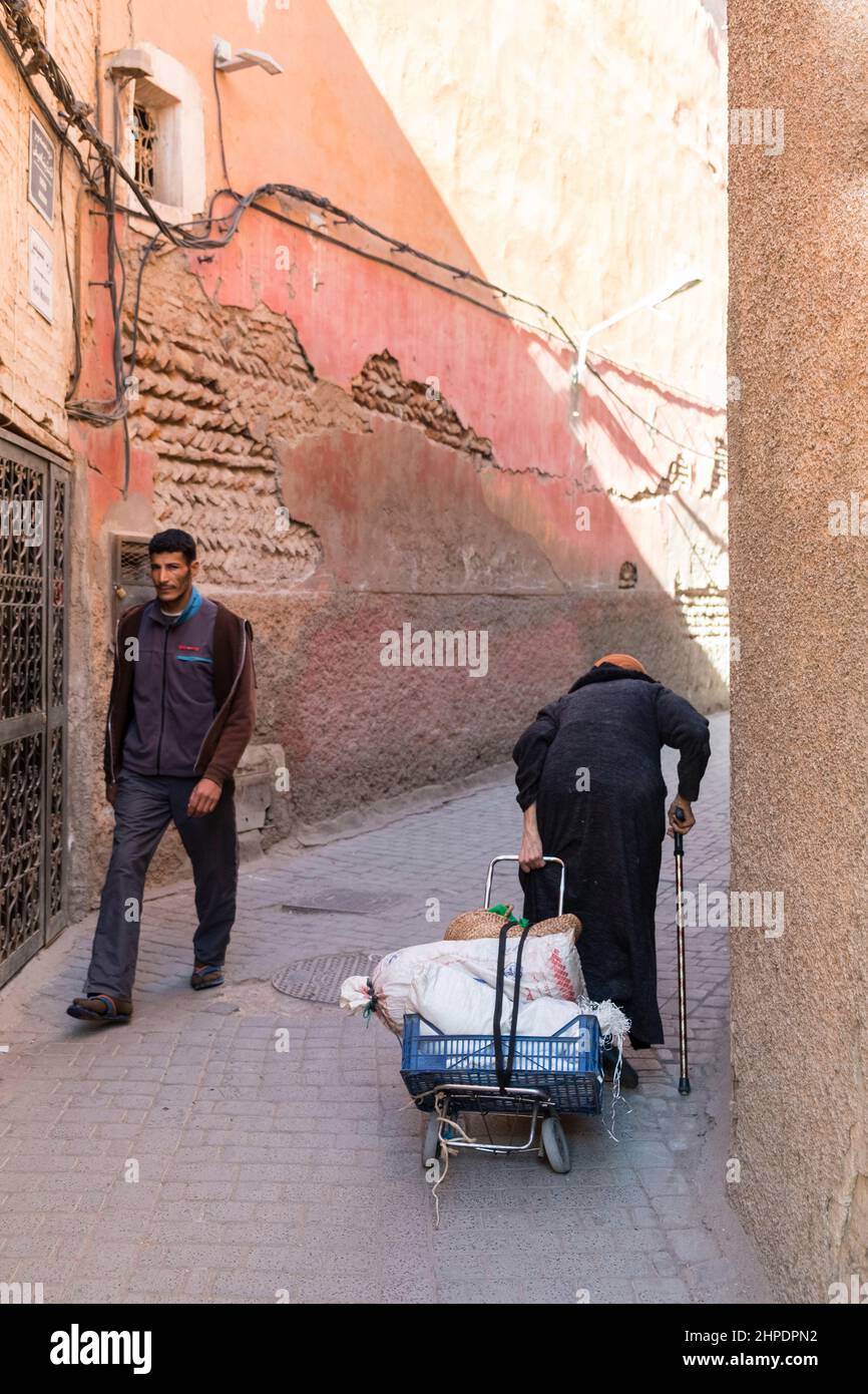 Marrakech locals navigate the narrow alleyways of the Medina Stock Photo