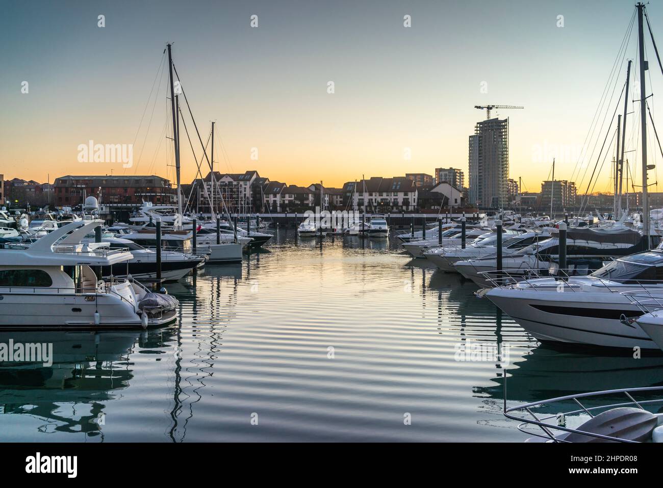 Boats moored at Ocean Village Marina at sunrise early morning with view to Woolston, Southampton, Hampshire, England, UK Stock Photo