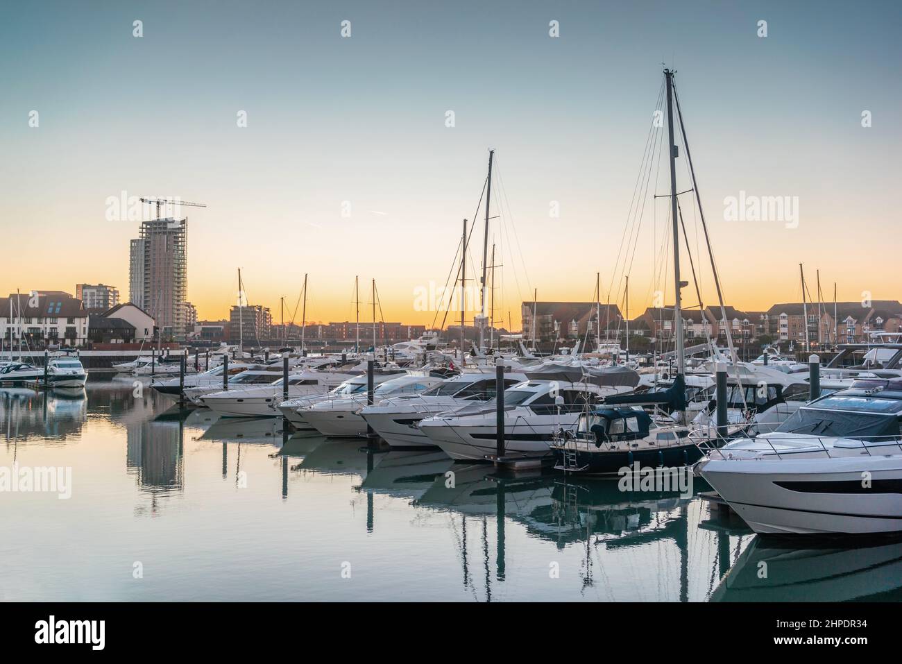 Boats moored at Ocean Village Marina at sunrise early morning with view to Woolston, Southampton, Hampshire, England, UK Stock Photo