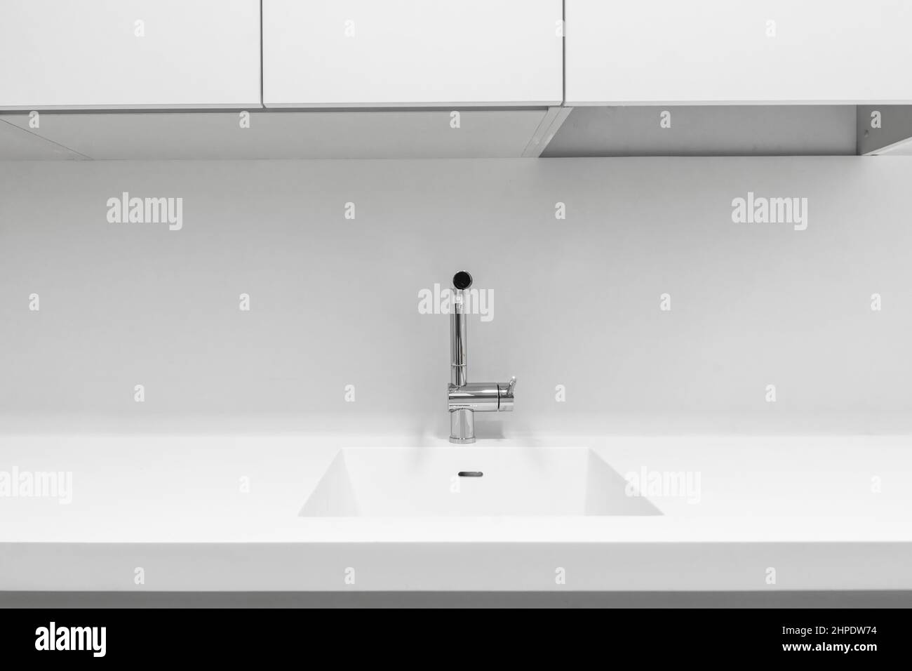 Onepiece sink joined with white countertop in a designer kitchen Stock