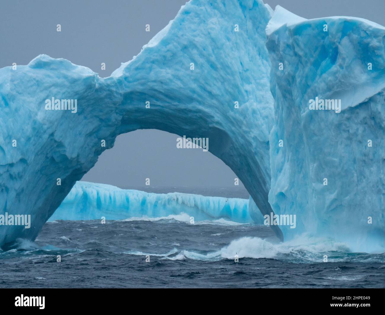A blue iceberg arch off the South Orkney Islands, Antarctica Stock Photo
