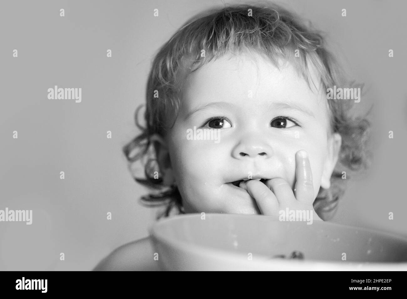 Smiling baby eating food. Healthy nutrition for kids. Funny child face closeup. Stock Photo