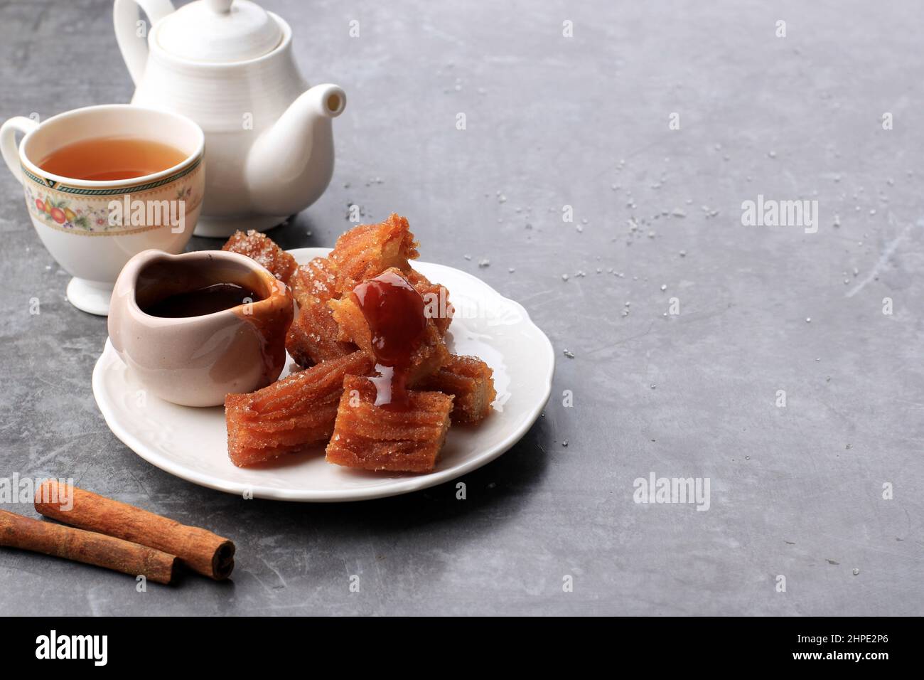 Homemade Mini Churros with Dulce de Leche, Served with Tea. Copy Space for Text Stock Photo