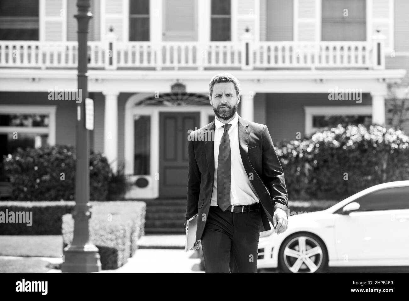 Real estate. Agent ready to sell home. Businessman standing outside a