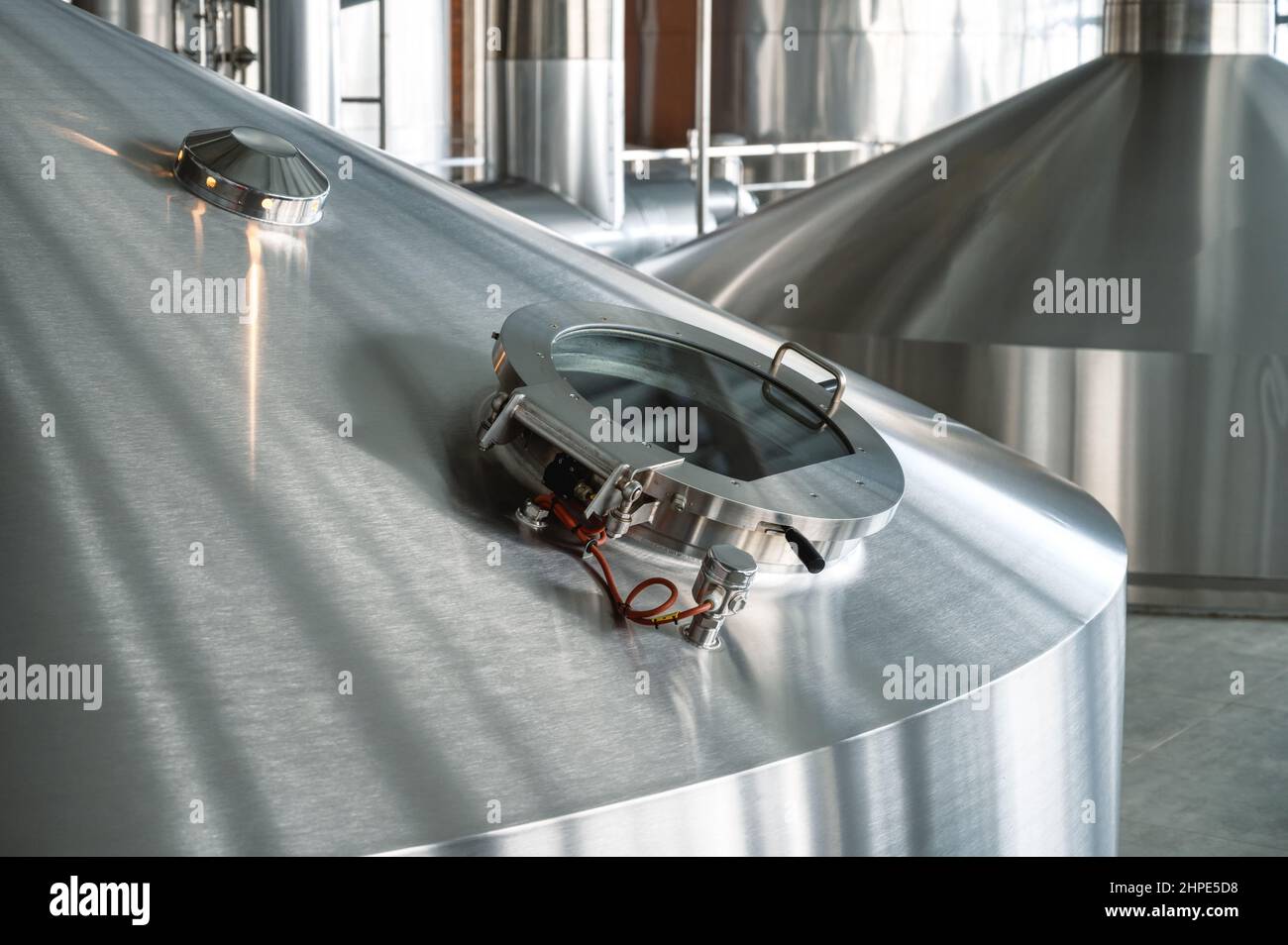 Large yeast fermentation tanks. Inspection glass hatch Industrial production of beer and alcohol Stock Photo