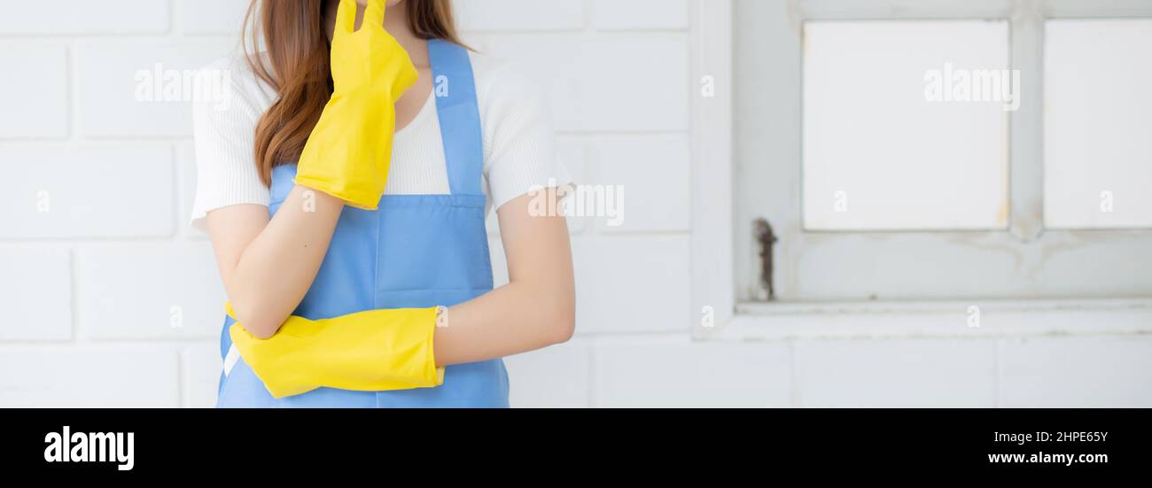 Portrait young asian woman is housekeeper in rubber gloves and apron ...