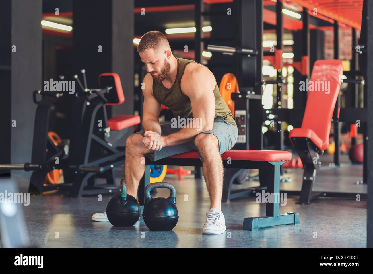 Young muscular guy training with kettlebells. Photo of sporty