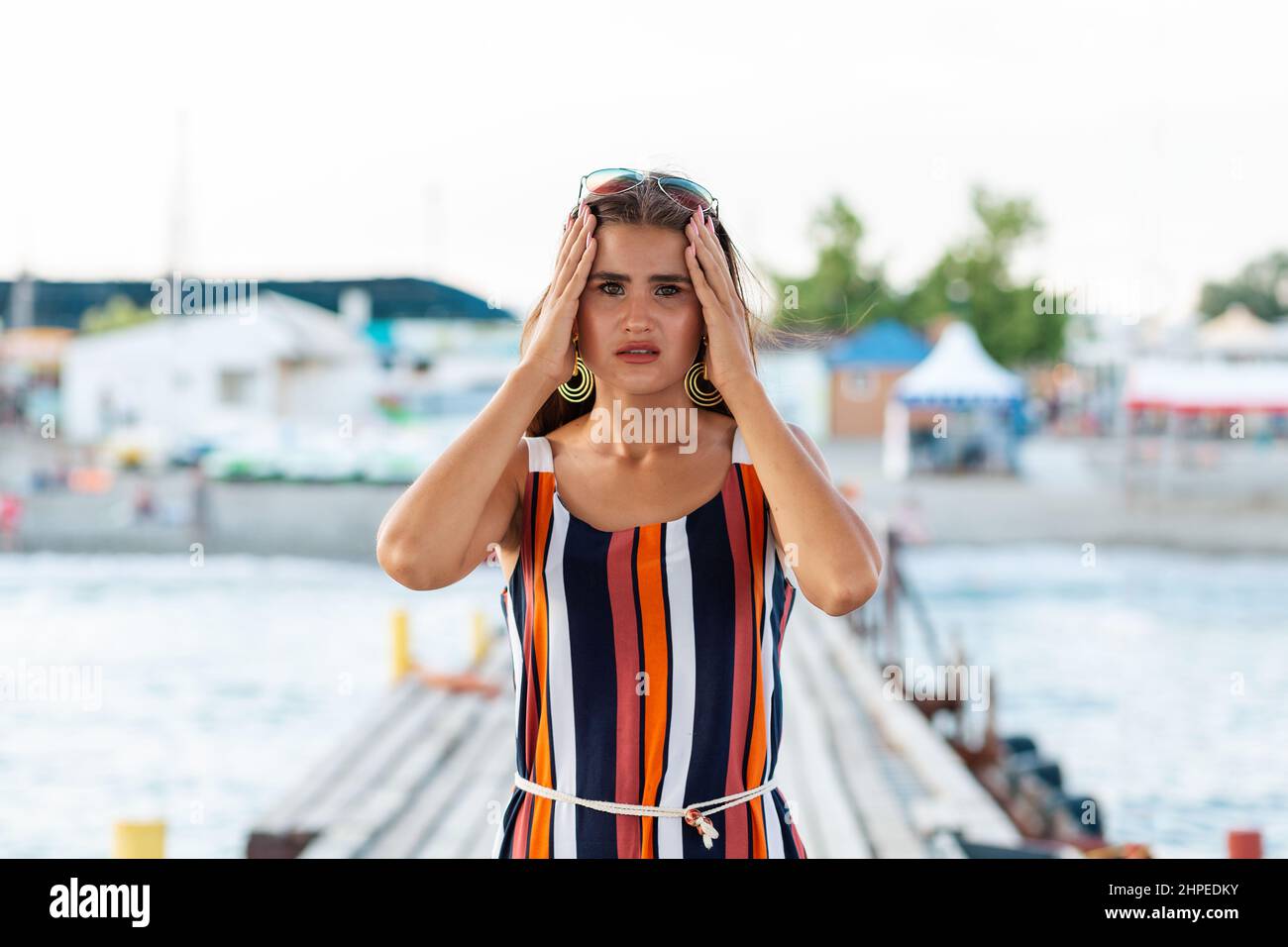 Stress. A woman with a suffering look, clutches her head with her hands