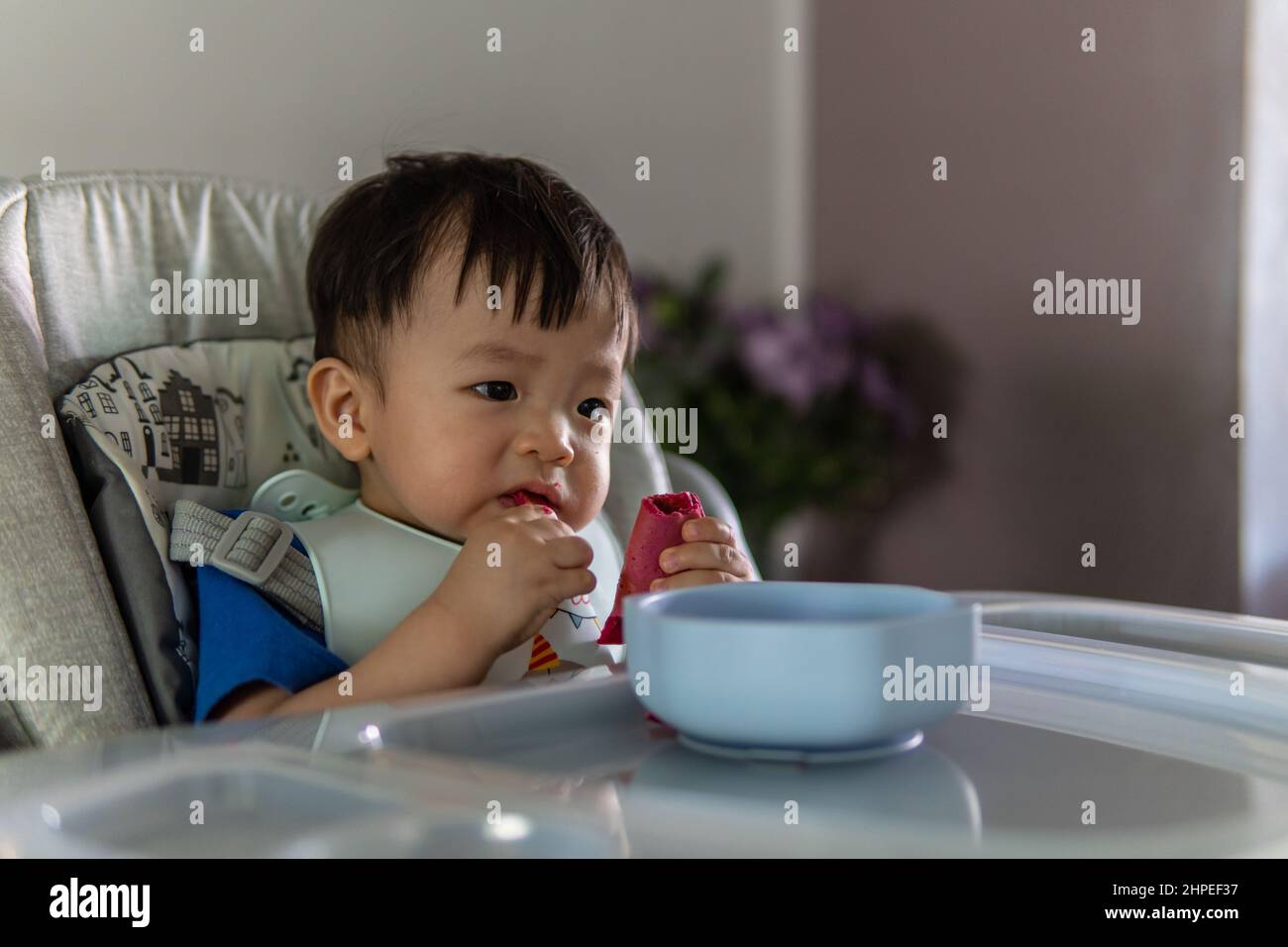 Adorable joyful and Happy 1 years old Chinese baby boy having food