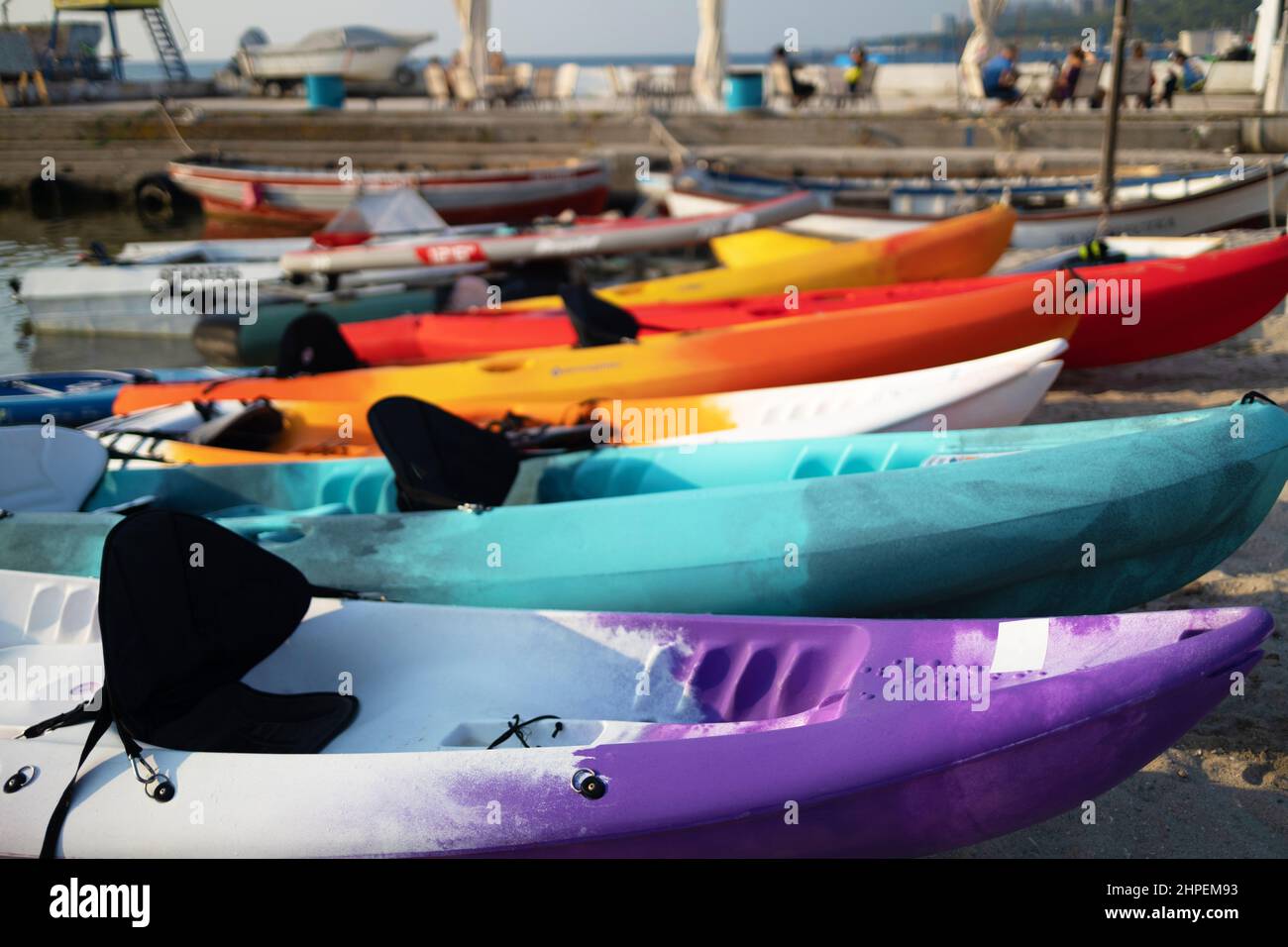 Colorful plactic kayaks or canoe on the beach sand for tourist rent ...