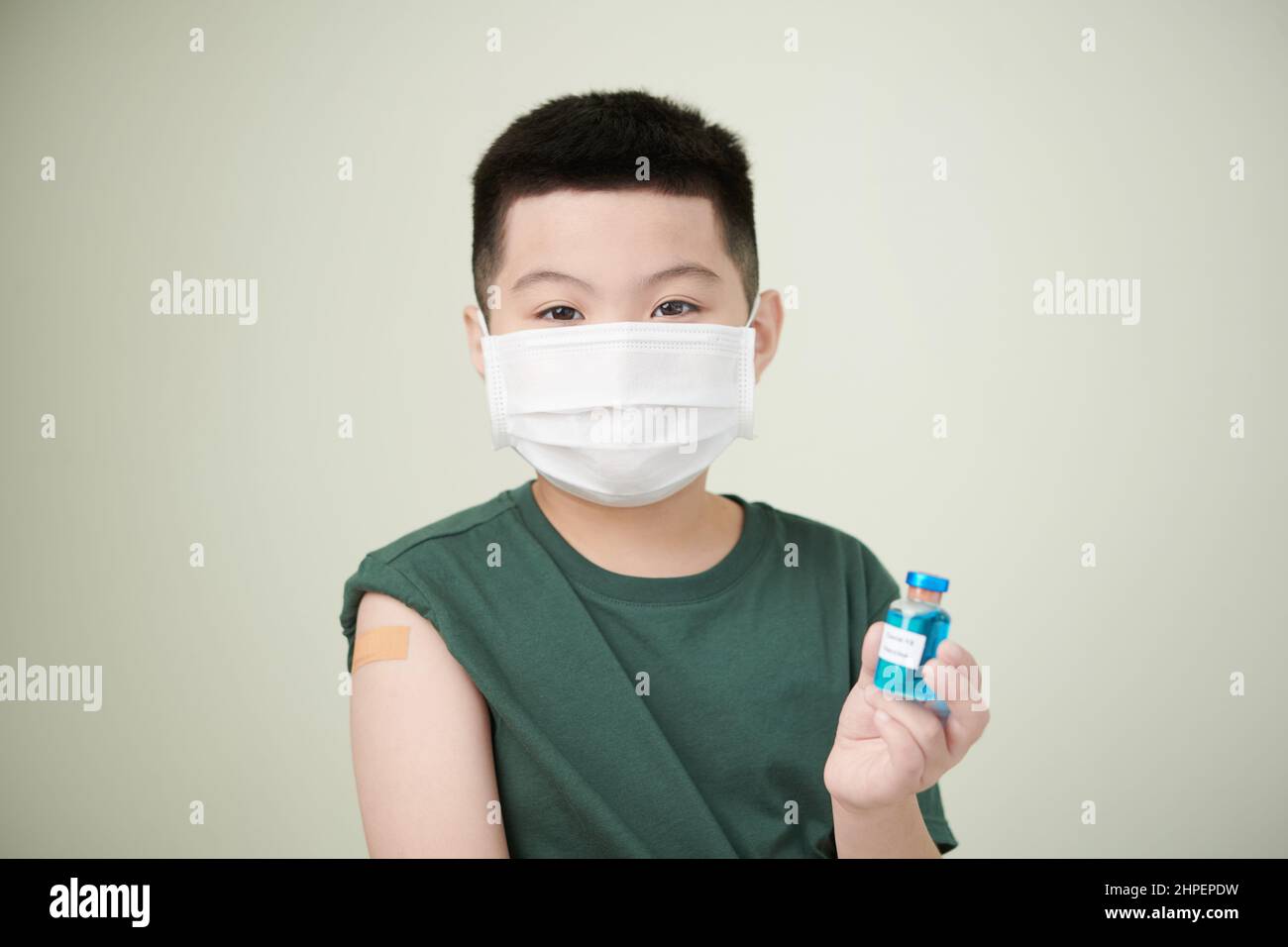 Portrait of little boy in mask with plaster on his shoulder after
