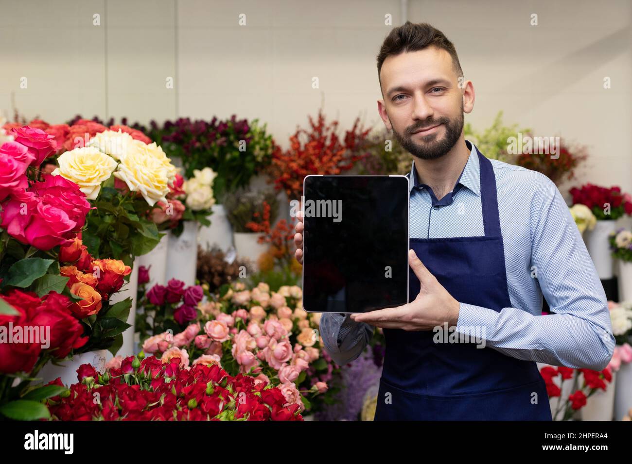 fresh flower warehouse owner showing tablet screen Stock Photo Alamy