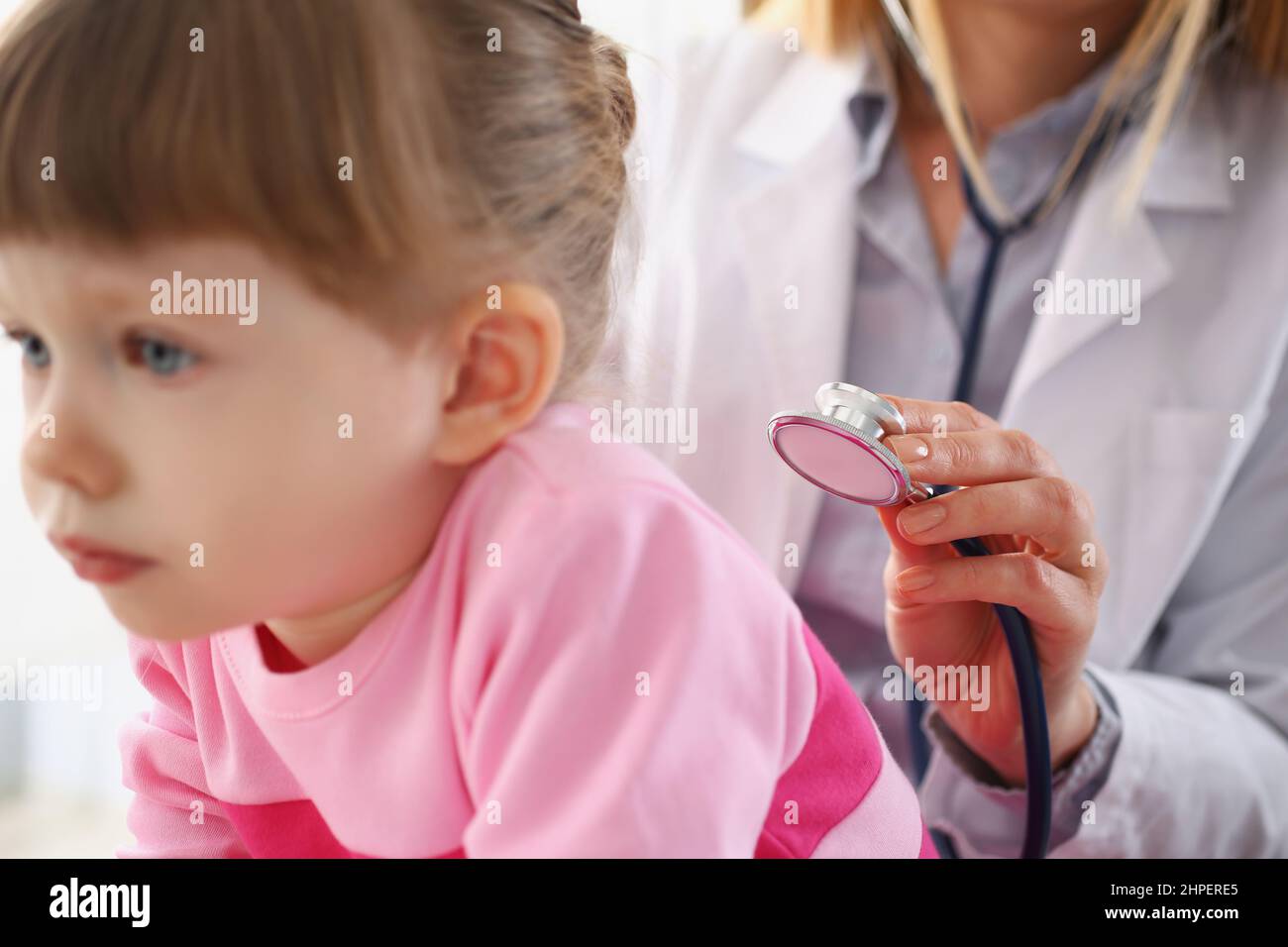 Little girl being examined by pediatrician female, calm child patiently waiting on appointment Stock Photo