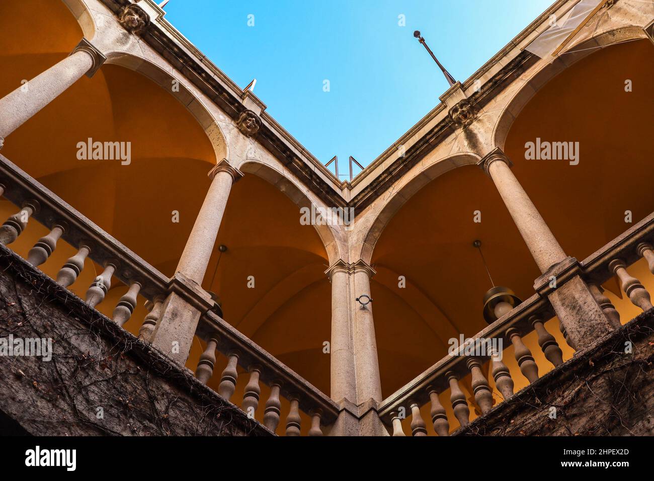 Look Up at Balcony with Columns in Palau del Lloctinent with Blue Sky in Barcelona. Architecture of Palace of the Viceroy. Stock Photo