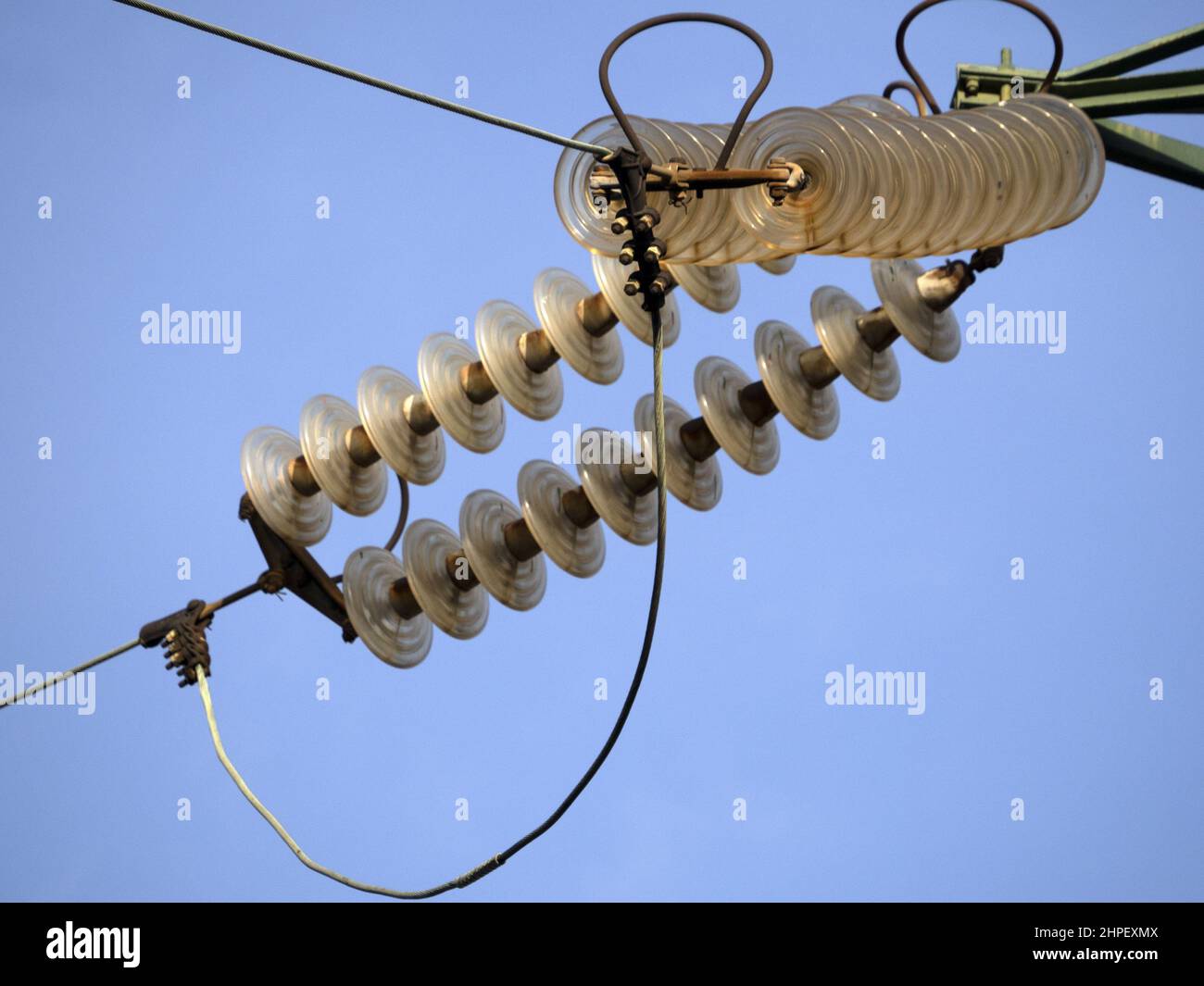 High Voltage electric wires cap and pin insulator detail on blue sky