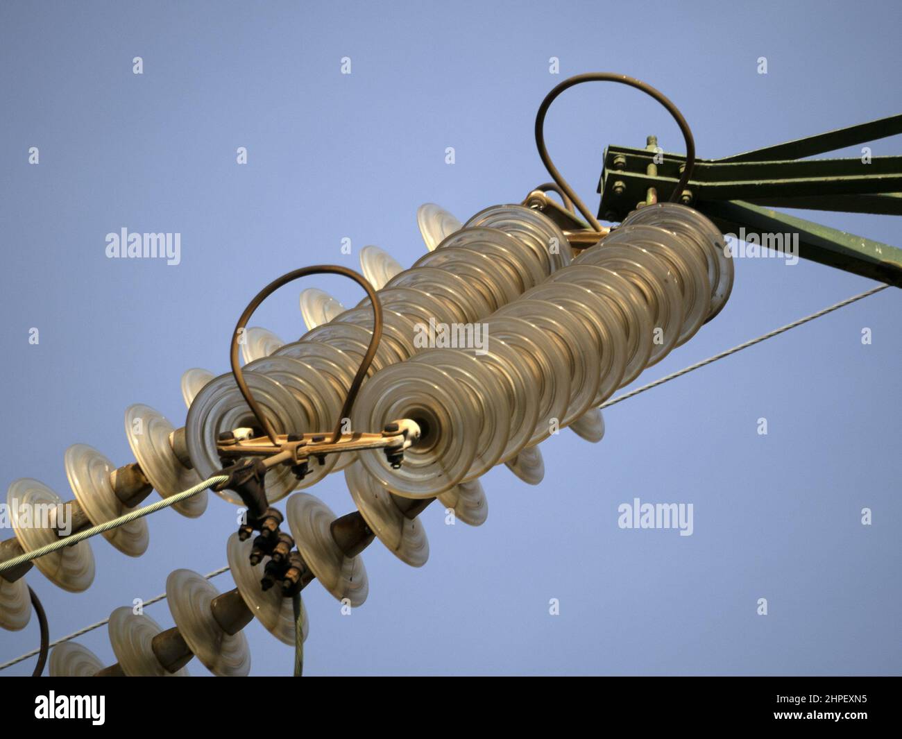 High Voltage electric wires cap and pin insulator detail on blue sky Stock Photo Alamy