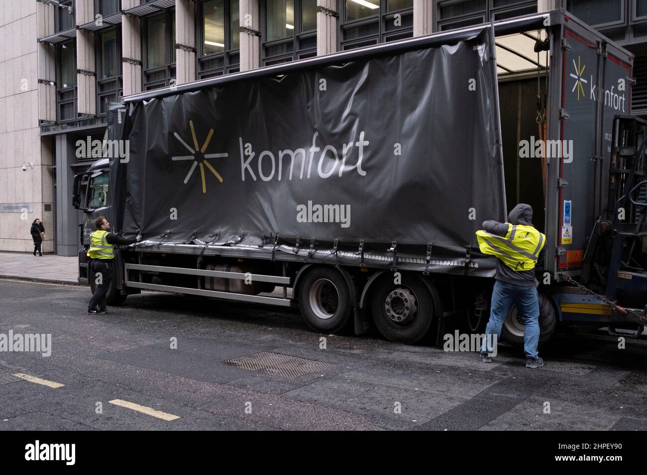 Delivery workers fight to secure side curtain on their lorry, as Storm Eunice sweeps across southern England and Wales and gale force winds sweep through the City of London, on 18th February 2022, in London, England. Stock Photo