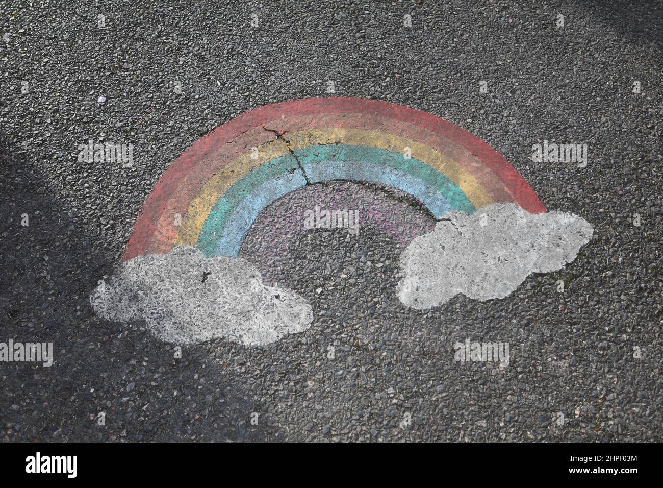 A rainbow painted on the floor of a playground in Harrow, London, UK. Stock Photo