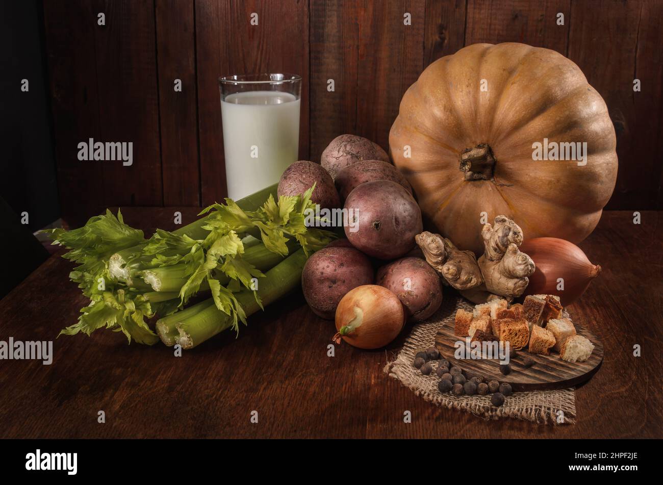 pumpkin, celery and other ingredients for pumpkin soup with breadcrumbs on a dark background Stock Photo