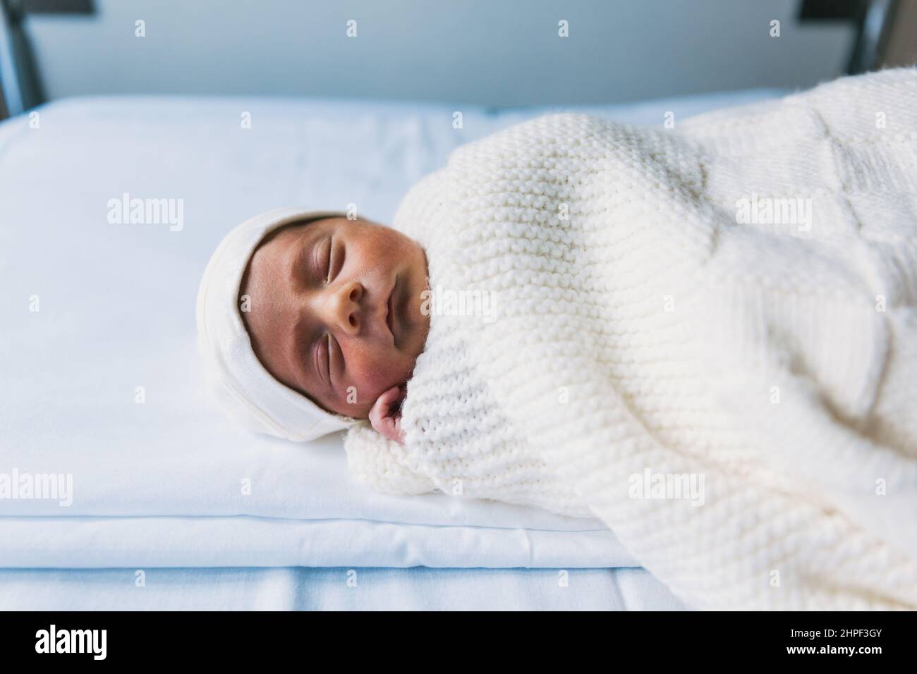 Newborn baby sleeping in his crib at the maternity hospital ward Stock