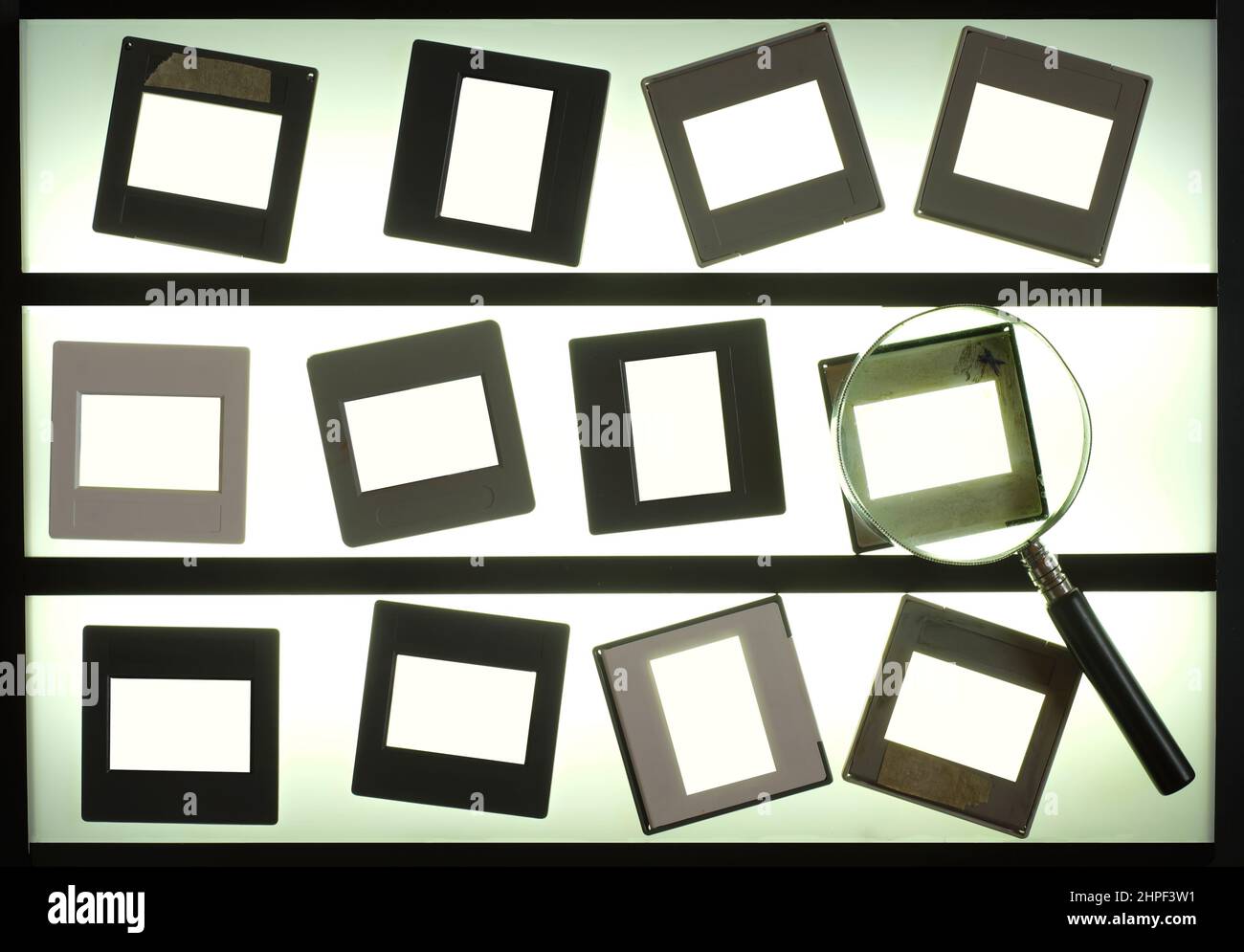 light table  with empty photographic slides and  magnifying glass,blank picture frames. anlog photography mock up. Stock Photo