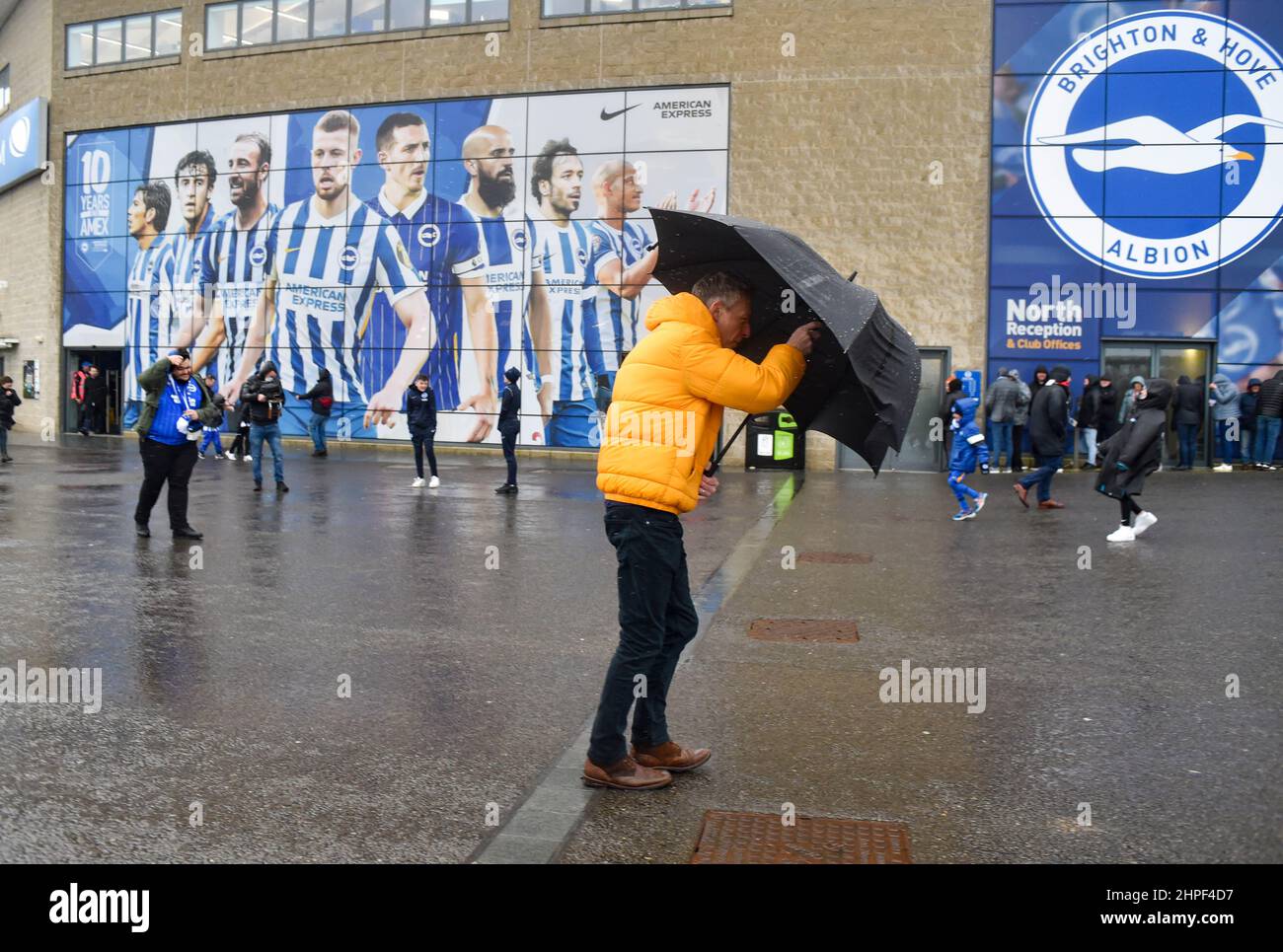 Fans arrive in the driving rain during the Premier League match between Brighton and Hove Albion and Burnley at The American Express Community Stadium, Brighton, UK - 19th February 2022 -  Editorial use only. No merchandising. For Football images FA and Premier League restrictions apply inc. no internet/mobile usage without FAPL license - for details contact Football Dataco Stock Photo
