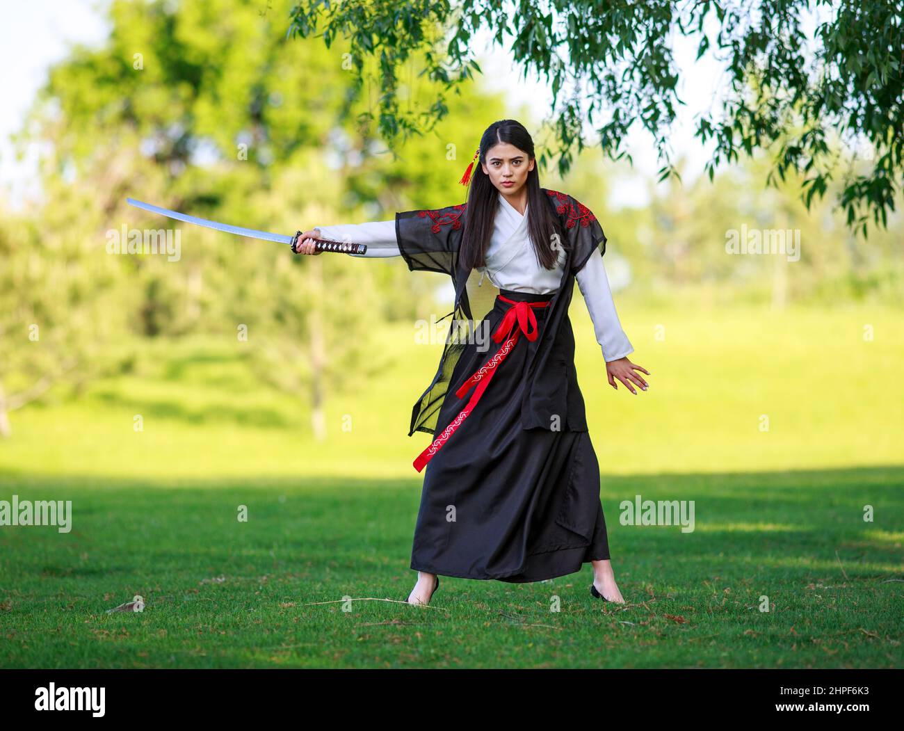Young asian woman in traditional kimono trains fighting techniques with