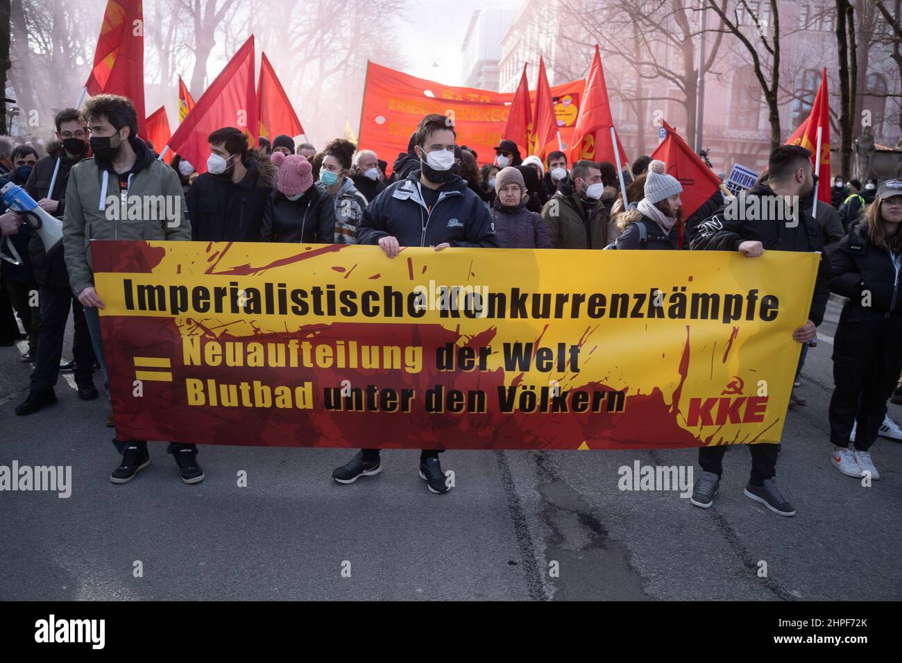 Munich, Germany. 19th Feb, 2022. Participants with banner „Imperialist Concurrence Fighting = Restarting the World Bloodbath among the Peoples KKE“. On February 19, 2022, thousands of participants gathered to demonstrate against the Munich Security Conference, against war & NATO and for peace. This year at the MSC, topics such as the Russia-Ukraine conflict are dealt with without Russia taking part in it. (Photo by Alexander Pohl/Sipa USA) Credit: Sipa USA/Alamy Live News Stock Photo
