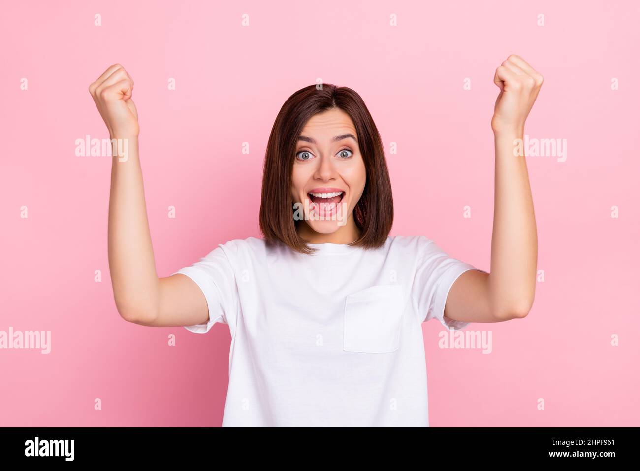 Photo of stunning female raise fists in victory triumph yelling hooray ...