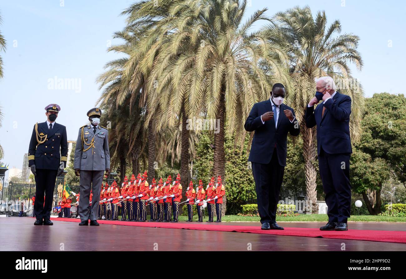Dakar, Senegal. 21st Feb, 2022. German President Frank-Walter Steinmeier (r) is greeted with military honors by Macky Sall, President of Senegal, at the Presidential Palace. President Steinmeier is on a three-day visit to the West African Republic of Senegal. Credit: Bernd von Jutrczenka/dpa/Alamy Live News Stock Photo
