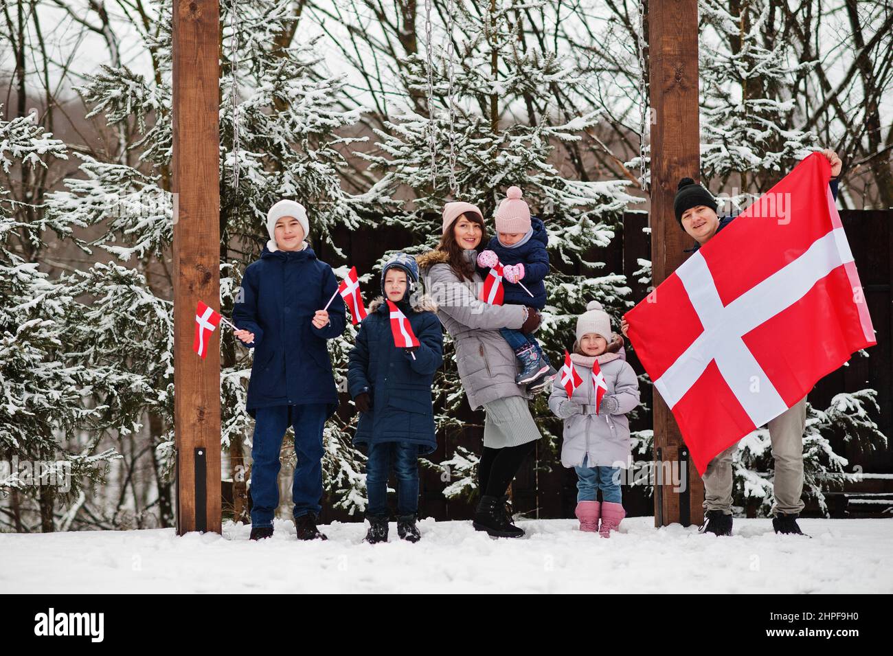 Family with Denmark flags outdoor in winter. Travel to Scandinavian countries. Happiest danish people's . Stock Photo
