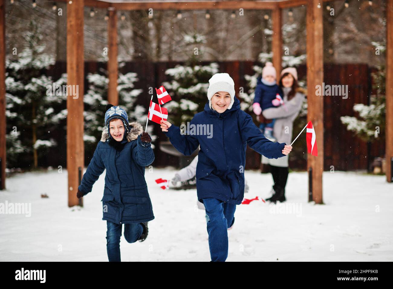 Family with Denmark flags outdoor in winter. Travel to Scandinavian countries. Happiest danish people's . Stock Photo