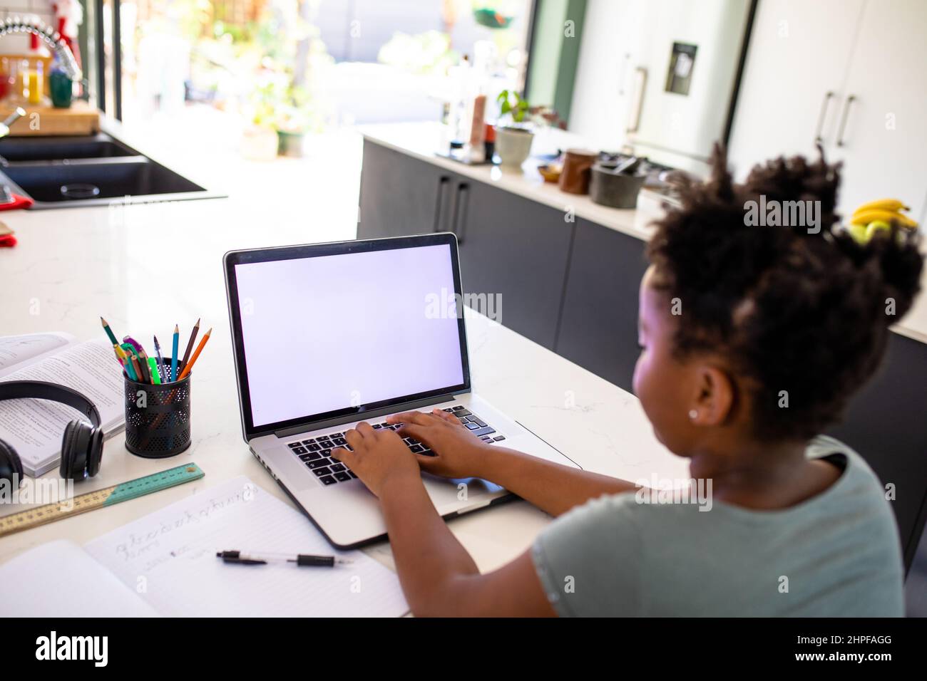 African american girl using laptop while e-learning at home, copy space Stock Photo