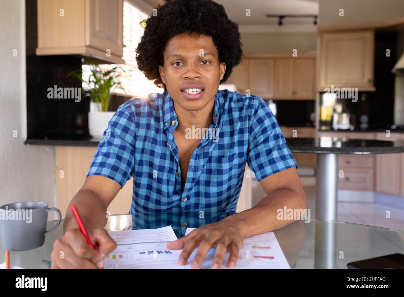 Portrait of multiracial male freelancer working in home office sitting at table Stock Photo