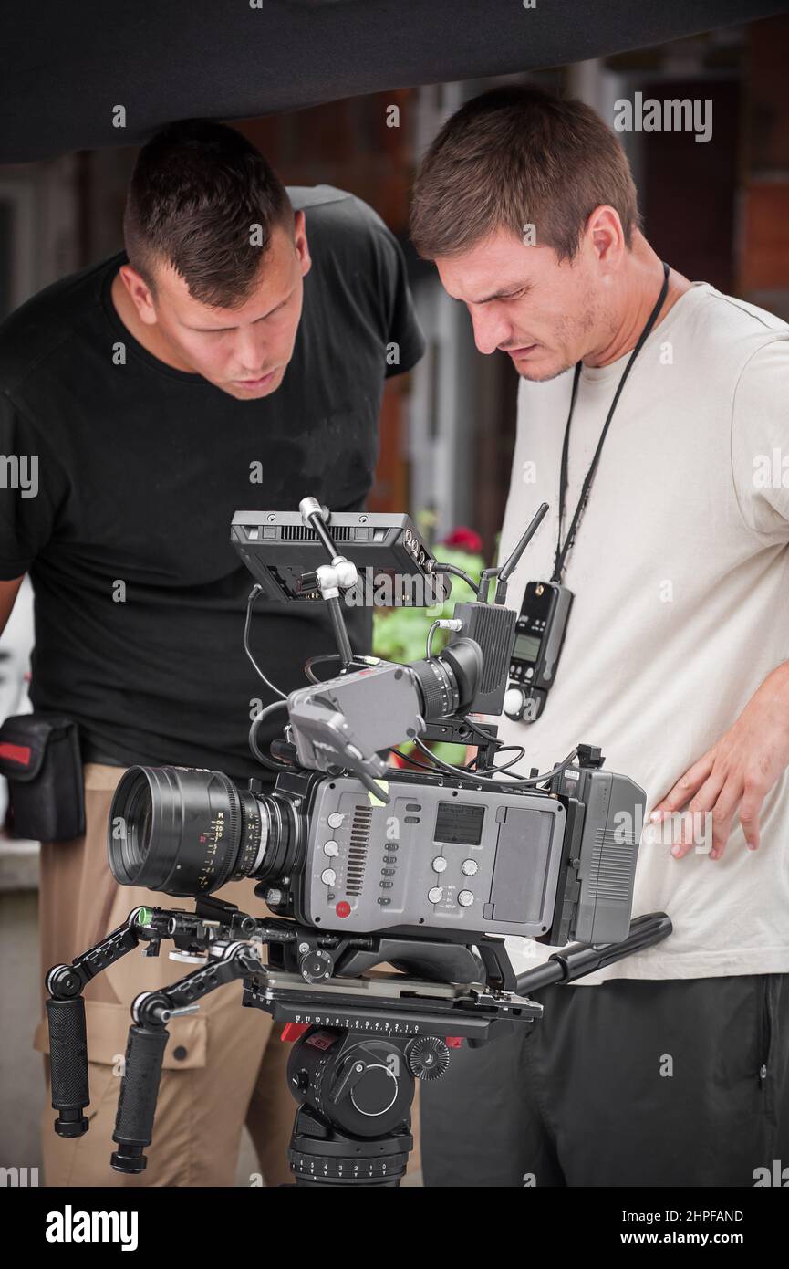 Behind the scenes. Cameraman shooting the film scene with his camera on outdoor set. Photography