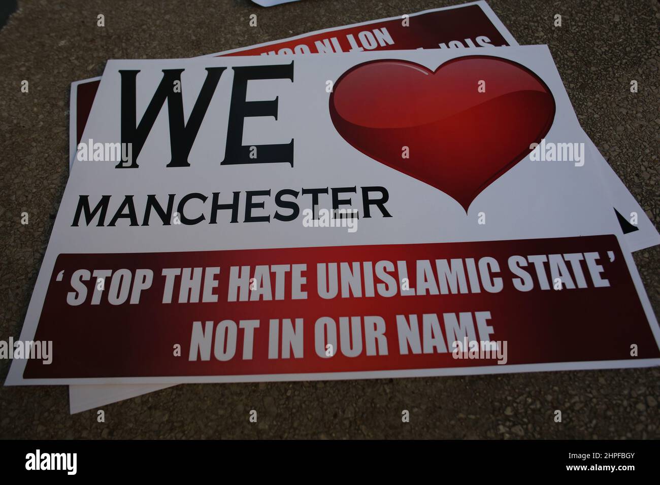 Young women pose for the camera holding a We Love Manchester sign in the wake of the bombing in 2017. Stock Photo