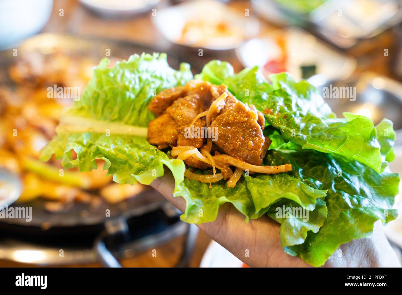 Close up of ssam Korean BBQ, pan-fried black pork with lettuce meal in Korea restaurant, fresh delicious korean cuisine. Stock Photo