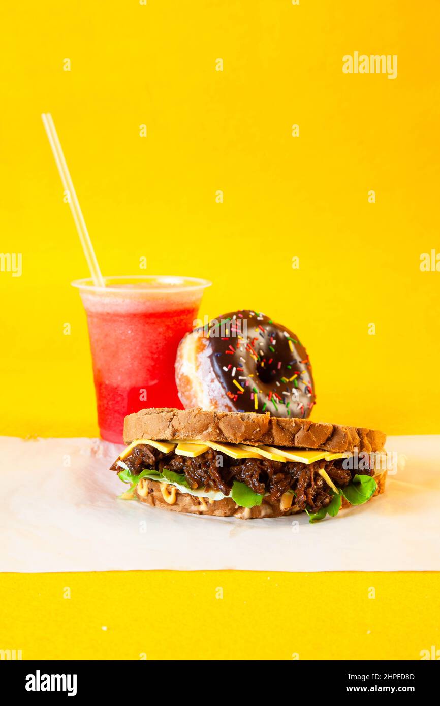Rye bread pulled beef sandwich with donut and slush drink Stock Photo
