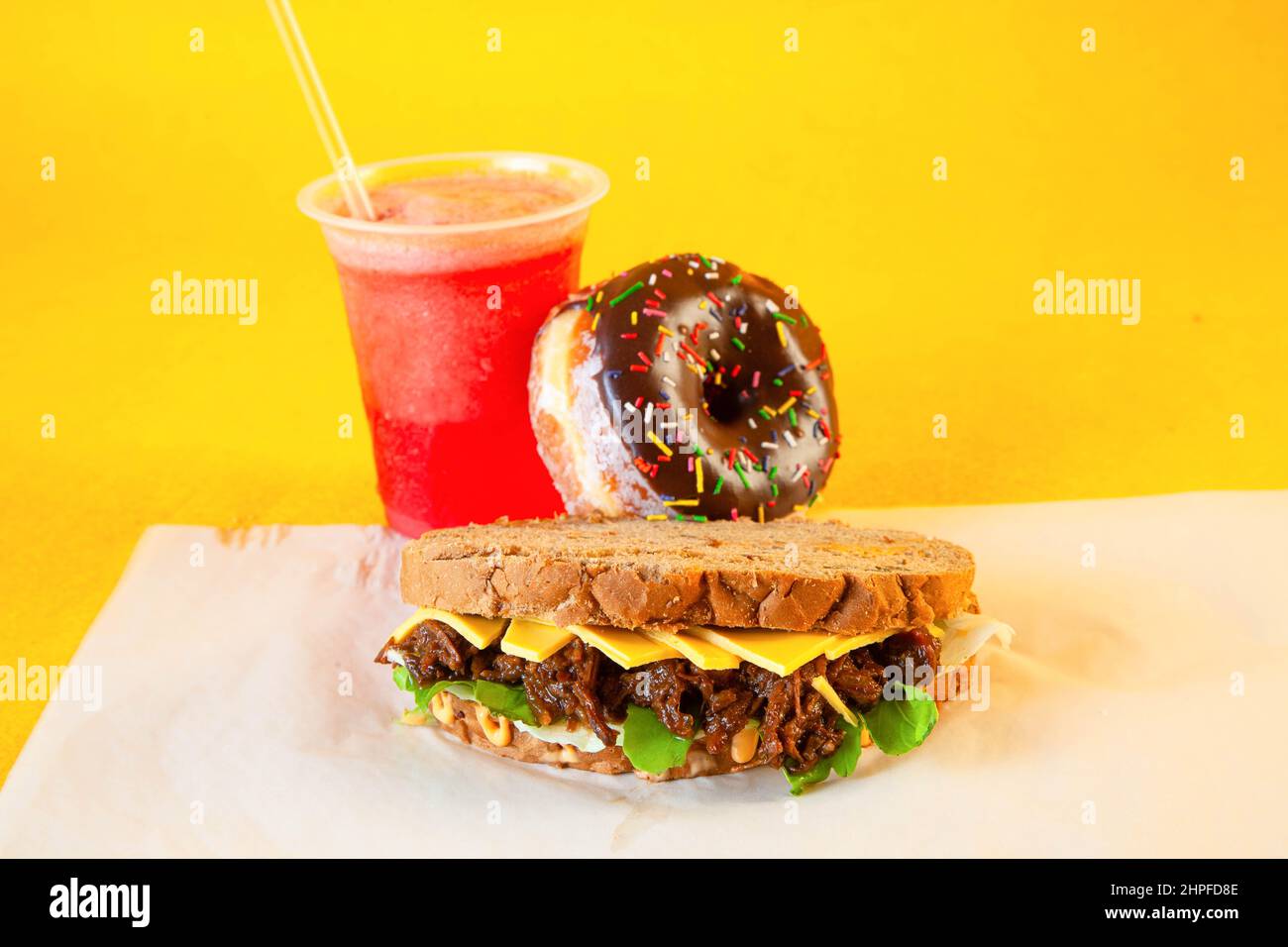 Rye bread pulled beef sandwich with donut and slush drink Stock Photo