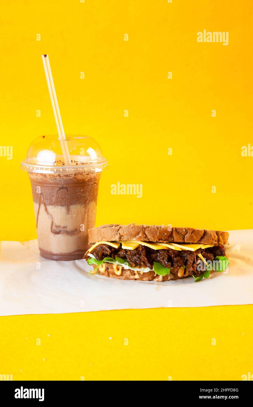 Rye bread pulled beef sandwich with donut and iced coffee drink Stock Photo