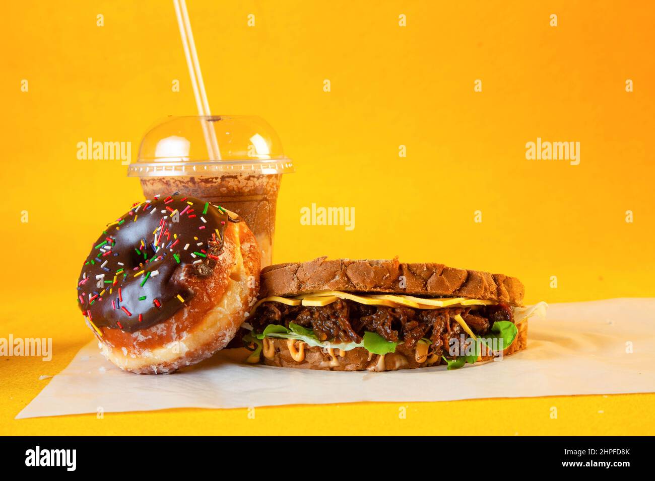 Rye bread pulled beef sandwich with donut and iced coffee drink Stock Photo