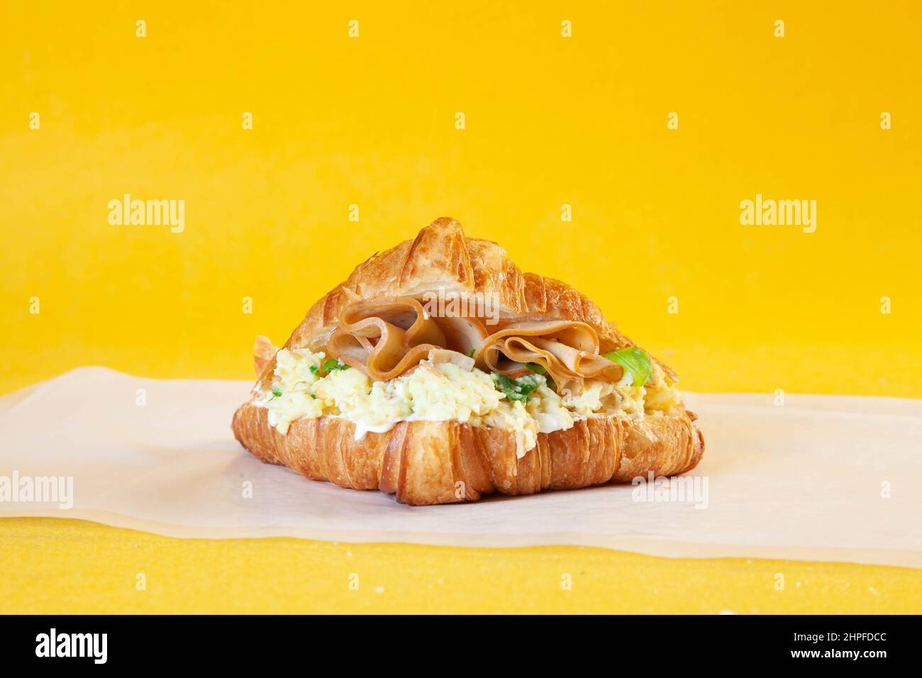 Brioched criossant scrambled egg sandwich. Stock Photo