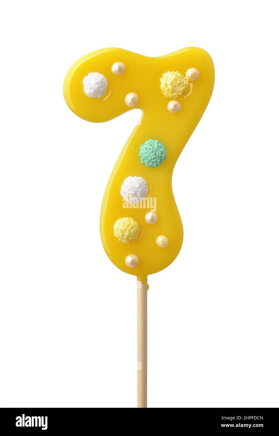 Front view of yellow handmade number seven lollipop isolated on white Stock Photo