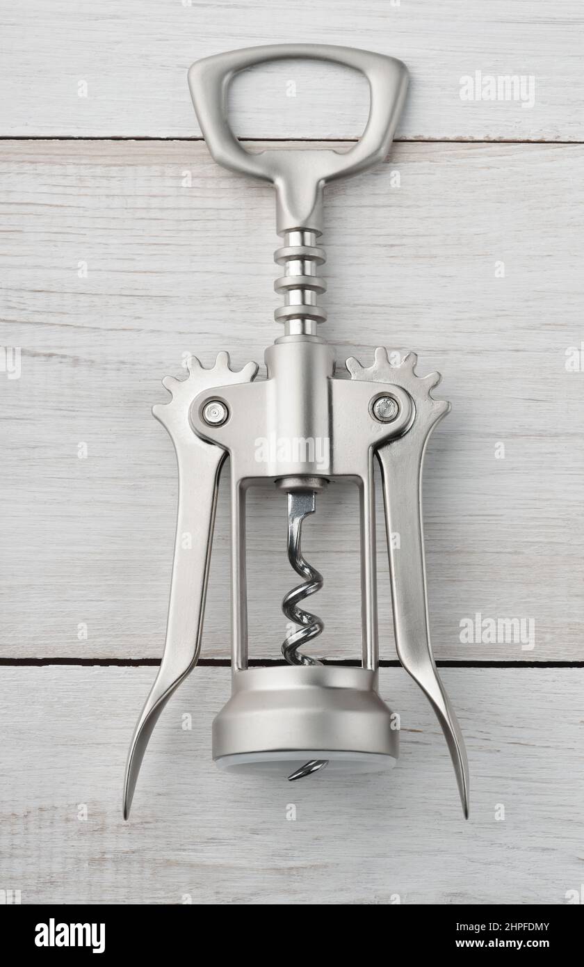 Front view of steel winged corkscrew bottle opener on white wooden