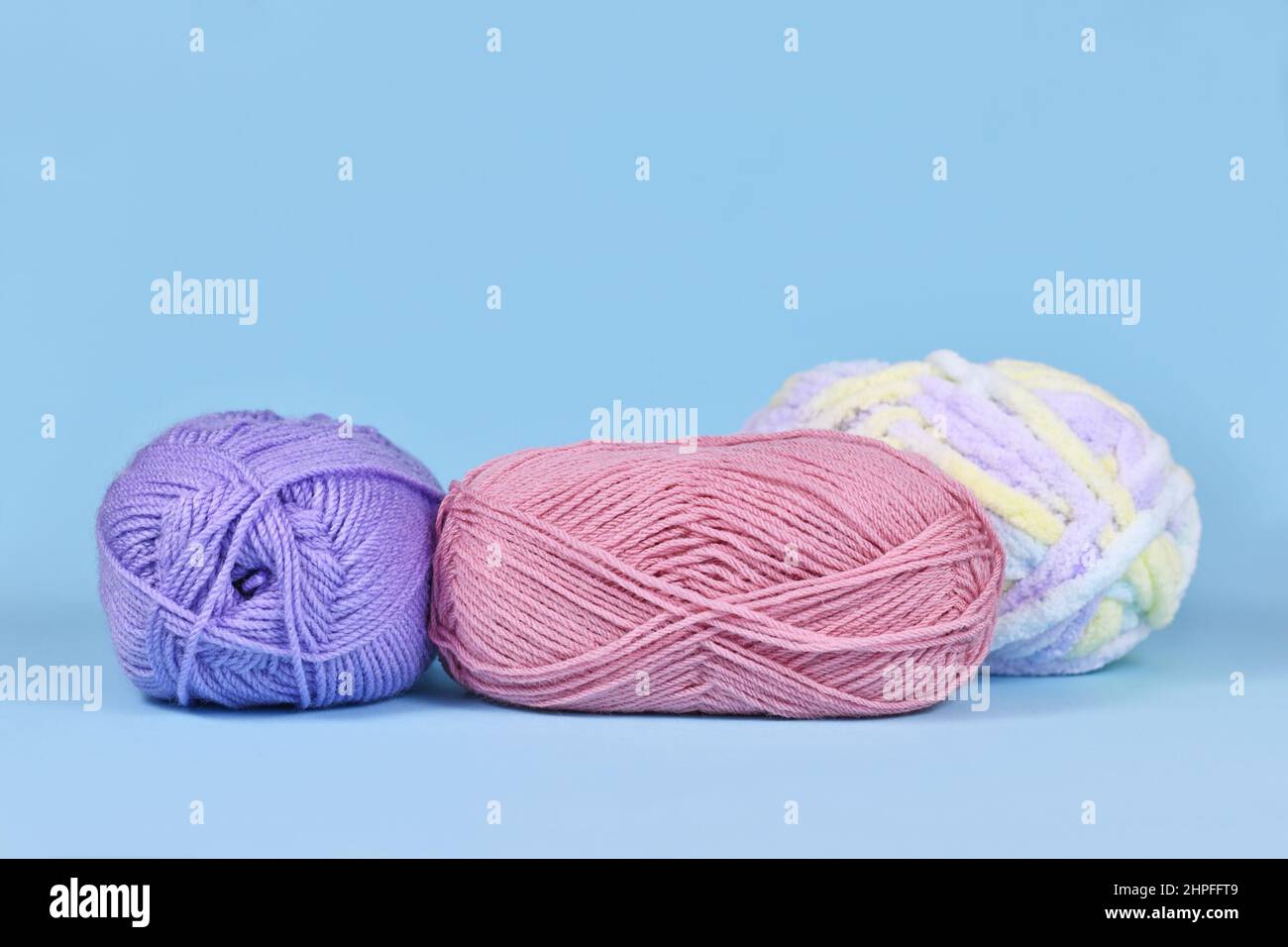 Balls of wool on pastel blue background Stock Photo
