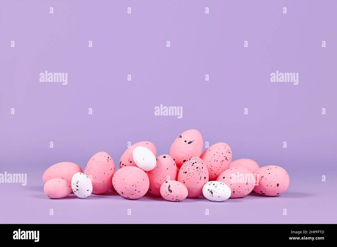 Pink Easter quail eggs on violet background with copy space Stock Photo