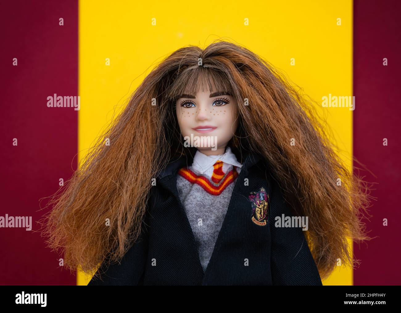 Tambov, Russian Federation - February 15, 2022 Portrait of a Mattel Harry Potter Hermione Granger Doll against red and yellow Gryffindor colors backgr Stock Photo