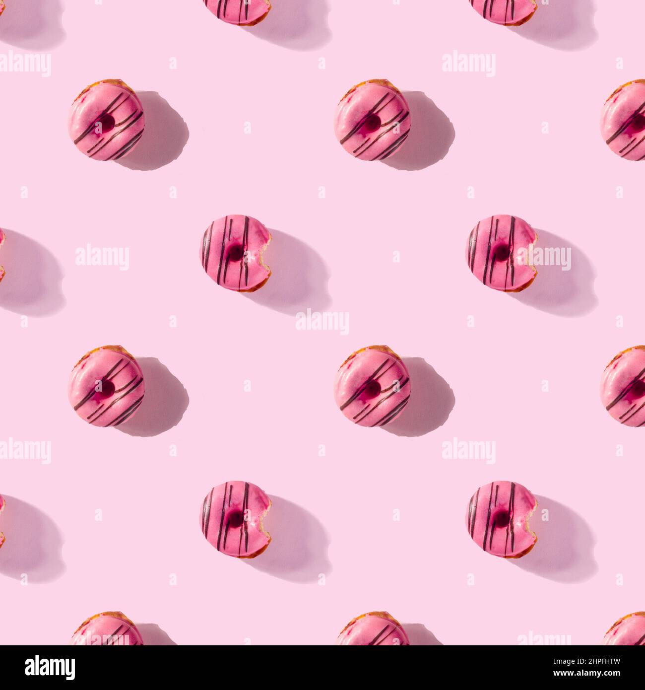 pattern made of Freshly baked donuts for breakfast on a pink background . Sweet background. Bakery, baking concept. Stock Photo