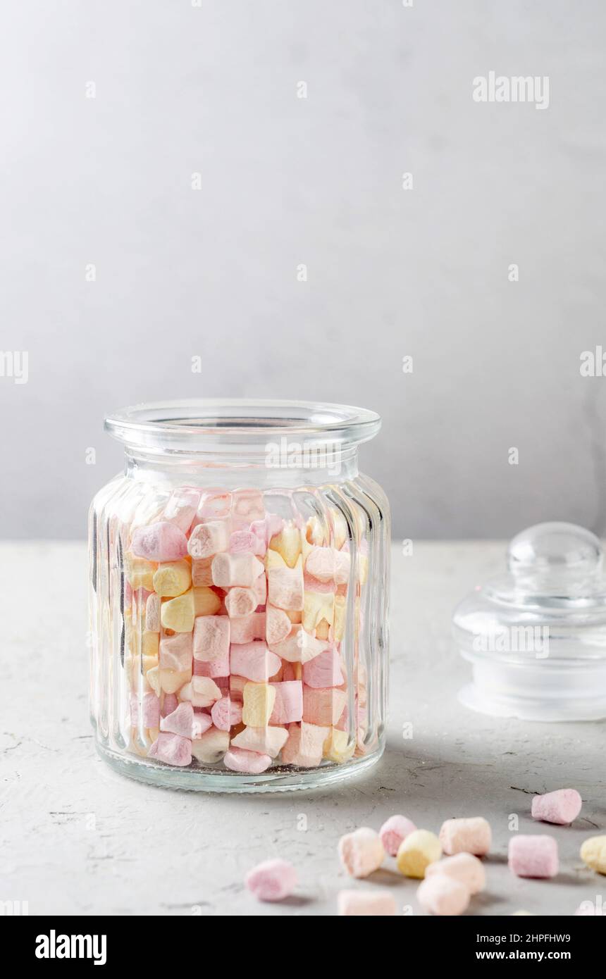 Pastel colorful marshmallow in glass jar on grey background. Selective Focus. Stock Photo