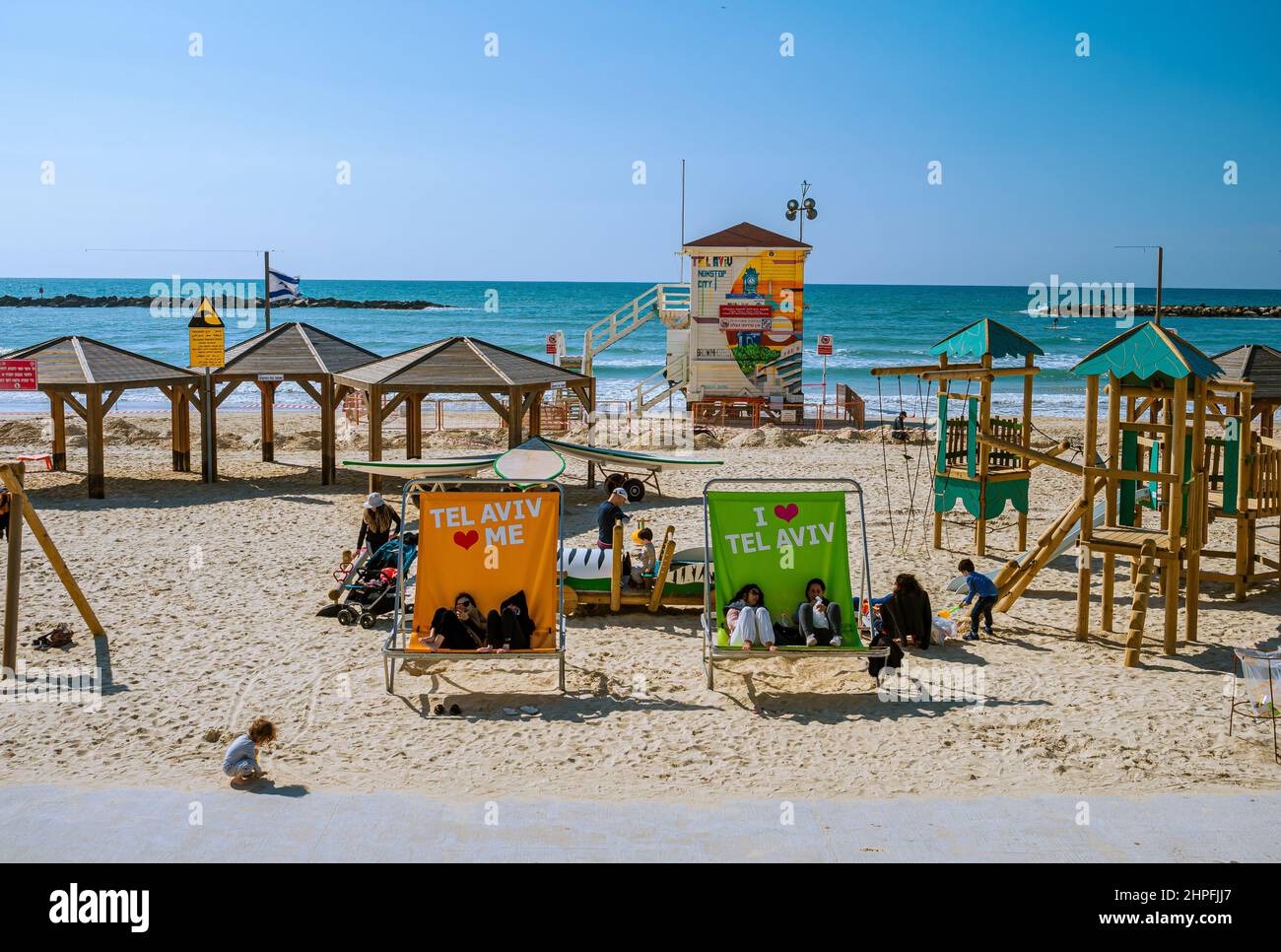 Tel-Aviv, Israel - March 26, 2019: White sand on the beach, seats, and umbrellas on the seaside in the summertime Stock Photo